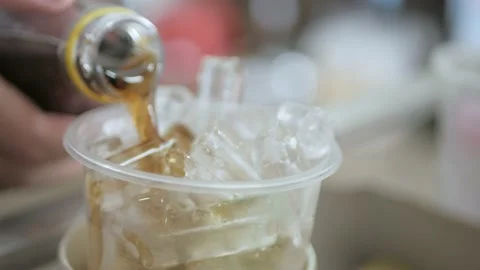 Pouring cola soda sparkling refreshment into the glass full with ice Stock-Footage 201843643