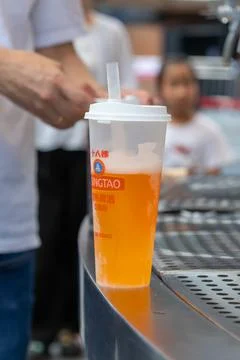Pouring cold beer into plastic cup with straw Stock Photos