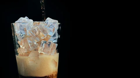 Pouring Cold Brew Coffee Over Ice in Glass, Black Background Stock Footage 348433209