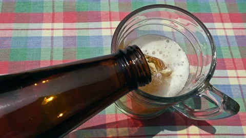 Pouring Cold Craft Beer from Bottle into Glass on Rustic Table Vídeo Stock 335787916