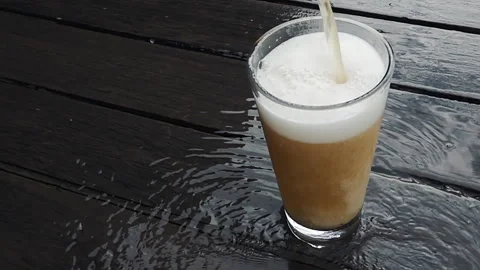 Pouring Cold Craft Beer with Frothy Foam Head on Wet Dark Wood Stock-Footage 335787903