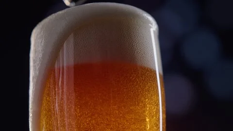 Pouring cold craft light beer with bubbles into glass  Stock Footage 257664534