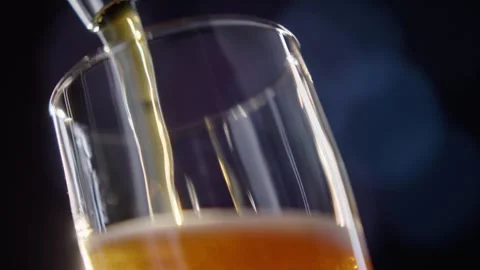 Pouring cold craft light beer with bubbles into glass  Stock Footage 257664929