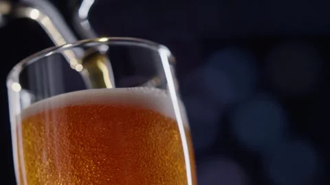 Pouring cold craft light beer with bubbles into glass  Stock Footage 257665120
