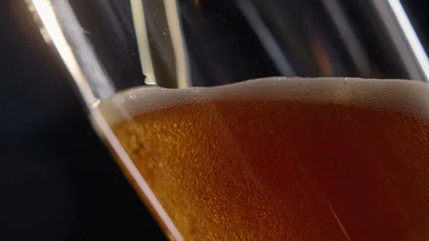 Pouring cold craft light beer with bubbles into glass  Stock Footage 257665465