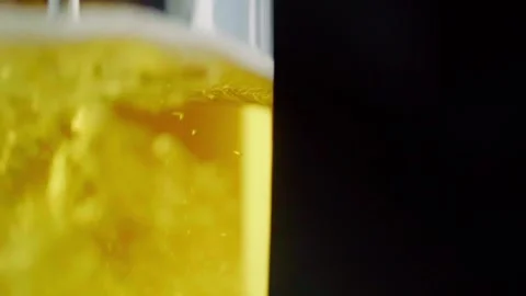 Pouring cold craft light beer with bubbles into glass  Stock Footage 257665528