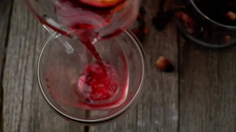 Pouring cold red tea with lemon to a heart shaped glass cup. View from above. Stock Footage