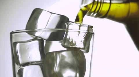 Pouring cold whiskey into the glass over white background Stock Footage 55876929