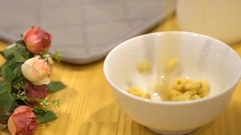 Pouring Corn Flakes O-ring to white bowl. Slow Motion Stock Footage 109418789