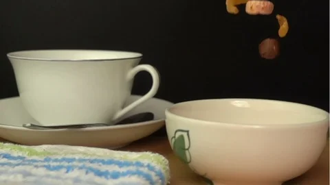 Pouring Cornflakes and Froot Loops into a white bowl Stock Footage 102271120