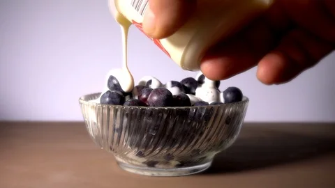 Pouring cream onto blueberries. Stock Footage 89869331