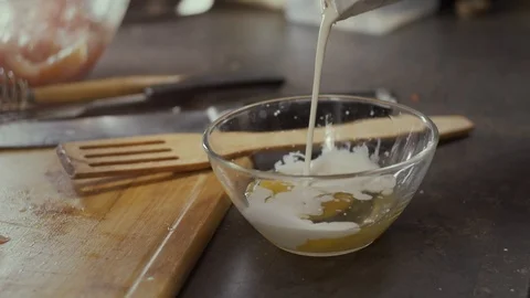 Pouring cream in egg in plate Stock Footage 126470485