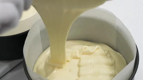 Pouring Creamy Batter into a Round Cake Pan Lined with Baking Paper Stock Footage 343020405
