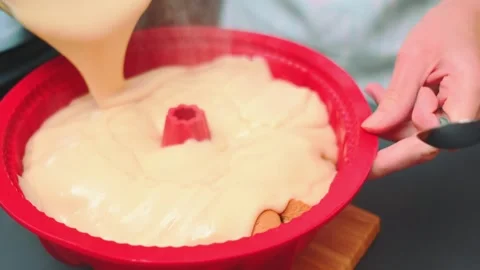 Pouring creamy pudding into red baking dish in kitchen Vidéo 342874420