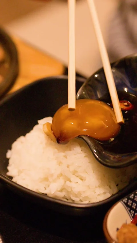 Pouring Cured Egg Yolk and Soy Sauce Over White Rice Stock Footage 343371397