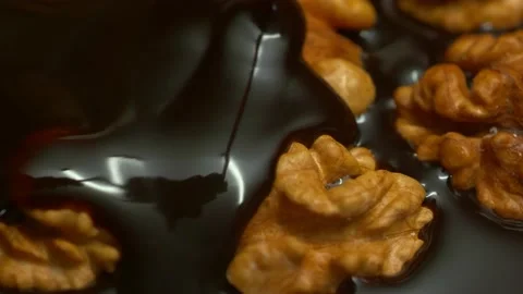 Pouring dark chocolate on walnuts top view Stock-Footage 162243586