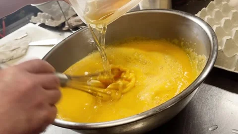 Pouring Dashi Broth into Beaten Eggs for Japanese Dashimaki Omelette, Japan Stock Footage 340752137