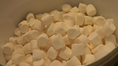 Pouring dessert marshmallows into a container Stock Footage 128354431