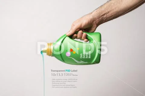 Pouring detergent liquid from green bottle in front of light gray background PSD Template