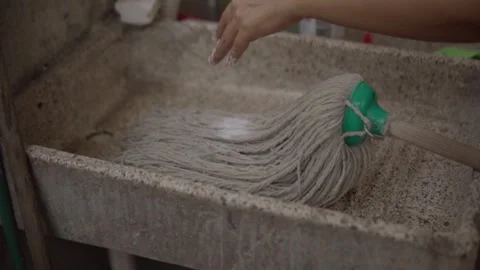 Pouring Detergent Powder Over Mop and Washing With Water in Utility Sink Stock Footage 345971715