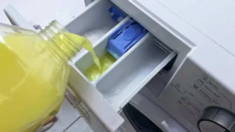 Pouring detergent into a washing machine drawer is essential for effective Stock Footage 282652788