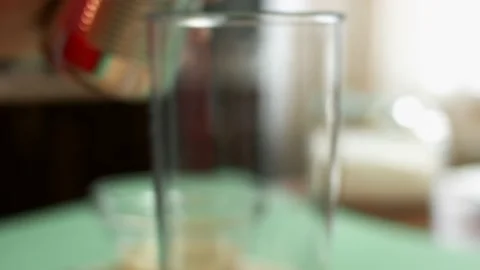 Pouring diced tomatoes from an open can into hand blender glass. Process of Stock Footage 151172467