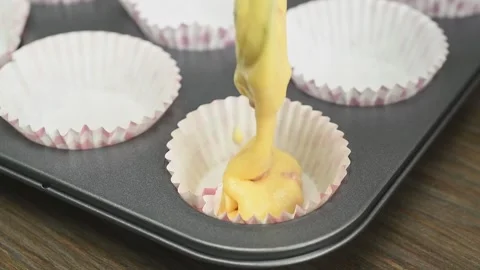 Pouring dough into forms for muffins.Process of preparing strawberry cupcakes. Stock Footage 194922669