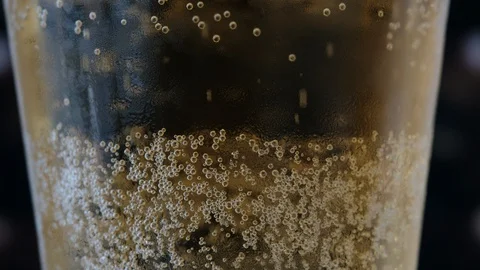 Pouring a draught lager beer from the top glass forming waves Stock Footage 87196498
