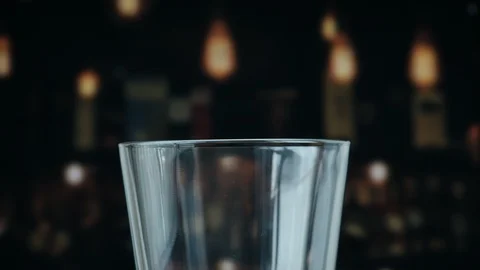 Pouring a draught lager beer from the top glass forming waves Stock Footage 87196680
