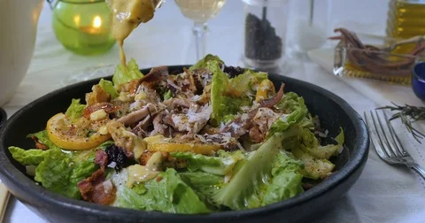 Pouring dressing sauce over a delicious Caesar's salad Stock Footage 76182804