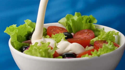 Pouring dressing sauce over fresh organic mixed homemade vegetarian salad Stock Footage 155377524