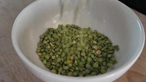 Pouring dried split peas into bowl from high angle Vídeo Stock 347011758