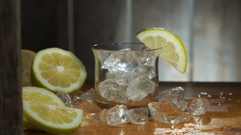 Pouring drink, ice and lemon on old table Stock Footage 111279392