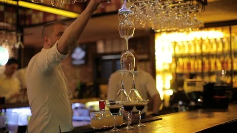 Pouring drink over a stack of glasses on fire Stock Footage 106184490