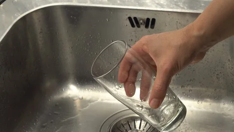 Pouring  drinking water from a kitchen tap into a glass. Stock Footage 108317876