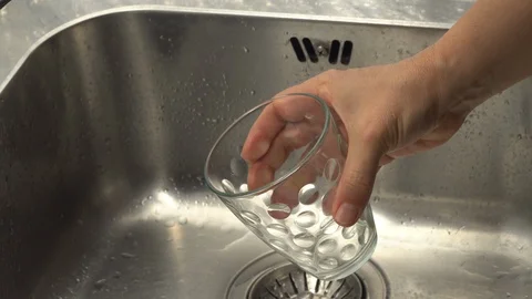 Pouring  drinking water from a kitchen tap into a glass. Video stock 108318176