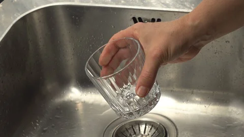 Pouring  drinking water from a kitchen tap into a glass. Video stock 108318189