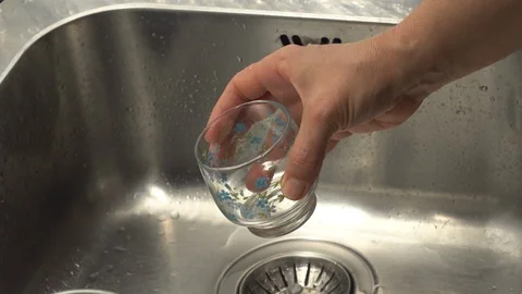 Pouring  drinking water from a kitchen tap into a glass. Video stock 108318244