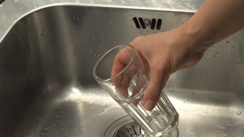 Pouring  drinking water from a kitchen tap into a glass. Video stock 108318254