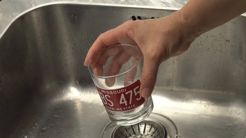 Pouring  drinking water from a kitchen tap into a glass. Video stock 108318581