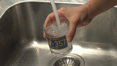 Pouring  drinking water from a kitchen tap into a glass. Video stock 108318582