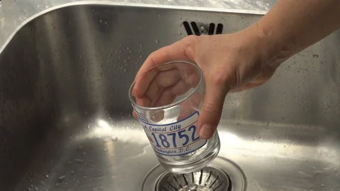 Pouring  drinking water from a kitchen tap into a glass. Video stock 108318715