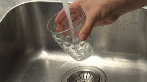 Pouring  drinking water from a kitchen tap into a glass. Video stock 108318960