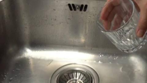 Pouring  drinking water from a kitchen tap into a glass. Video stock 108319082