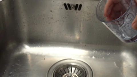 Pouring  drinking water from a kitchen tap into a glass. Video stock 108319355