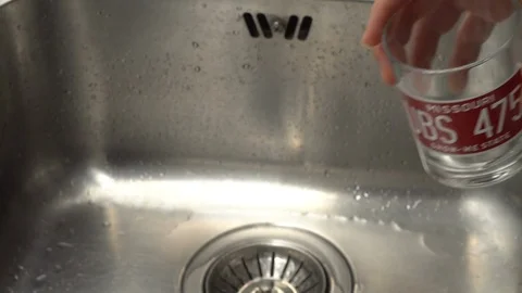 Pouring  drinking water from a kitchen tap into a glass. Video stock 108319435