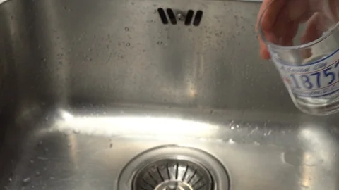 Pouring  drinking water from a kitchen tap into a glass. Video stock 108319478