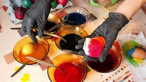 Pouring dye on napkin wrapped Easter egg close up Stock Footage 332970709