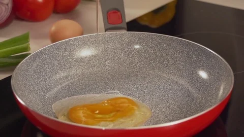 Pouring an egg into a pan in slow motion Stock Footage 81817010