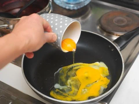 Pouring the eggs into a pan Stockfoto's